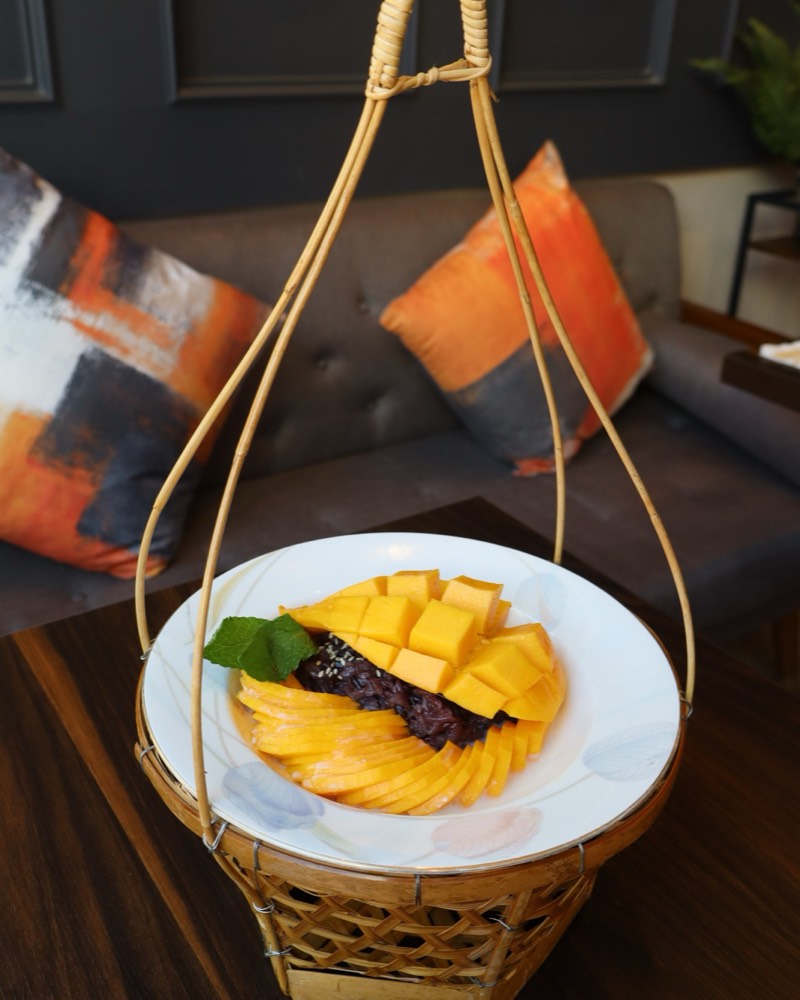 Mango sticky rice: black sticky rice with fanned and cubed ripe mango and fresh mint, served in a woven bamboo basket