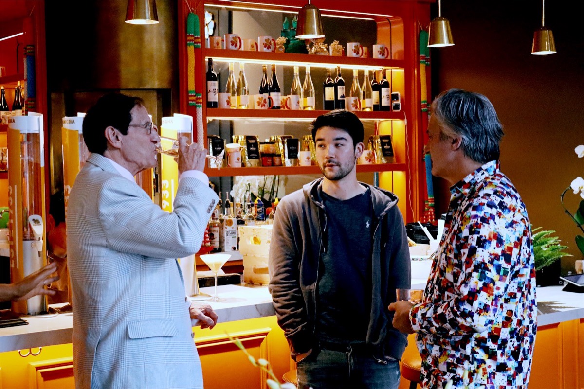 Three guests talking with drinks at the orange bar