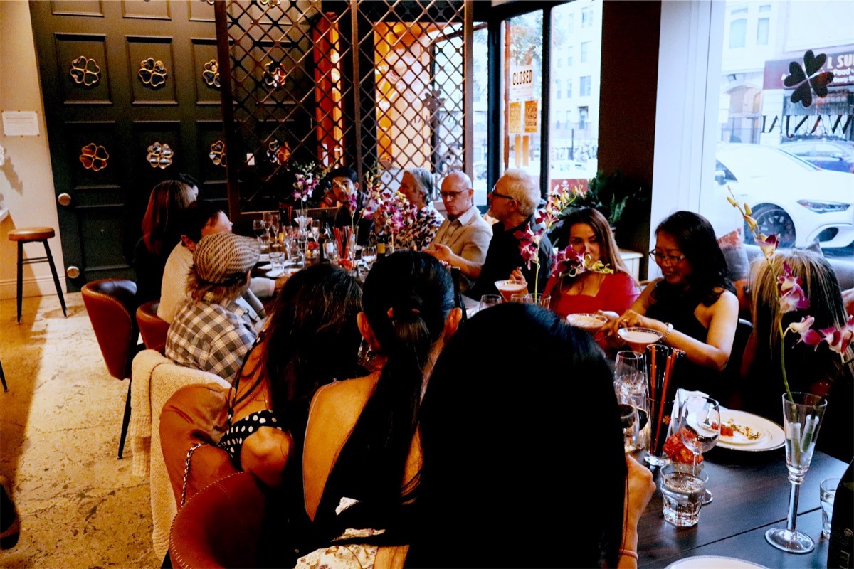 The long party table full of guests, seen from the end of the room