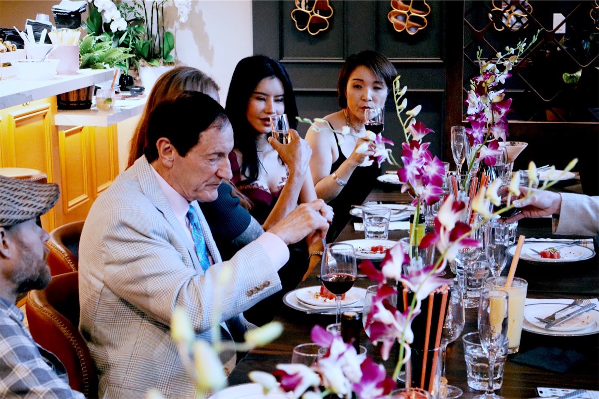Guests raising their glasses at the table