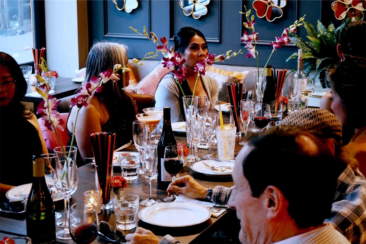 Guests at the table with orchids, candles and wine