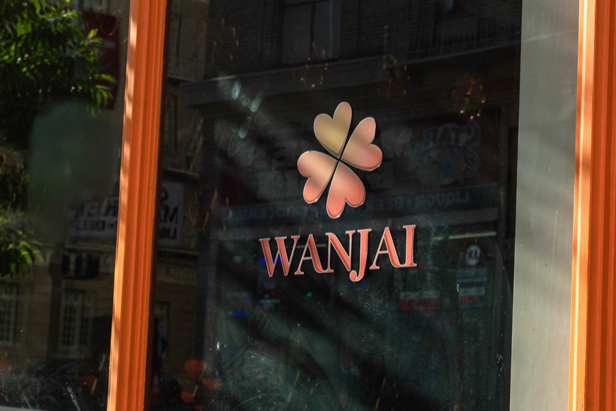 The Wanjai clover logo on the front window, framed in orange